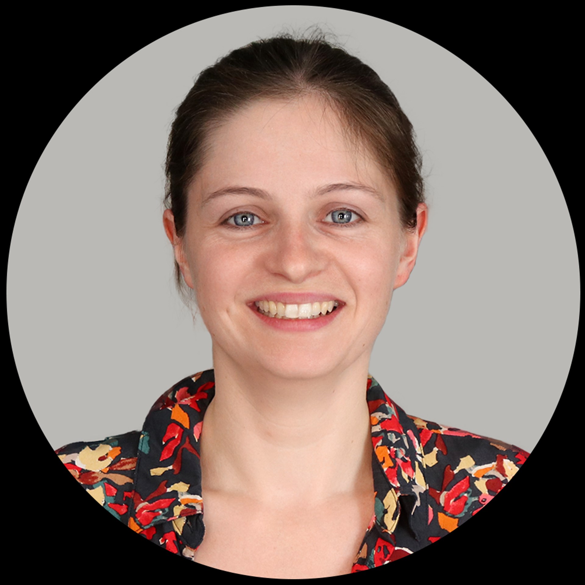 Das Portrait einer jungen blonden Frau mit farbiger Bluse