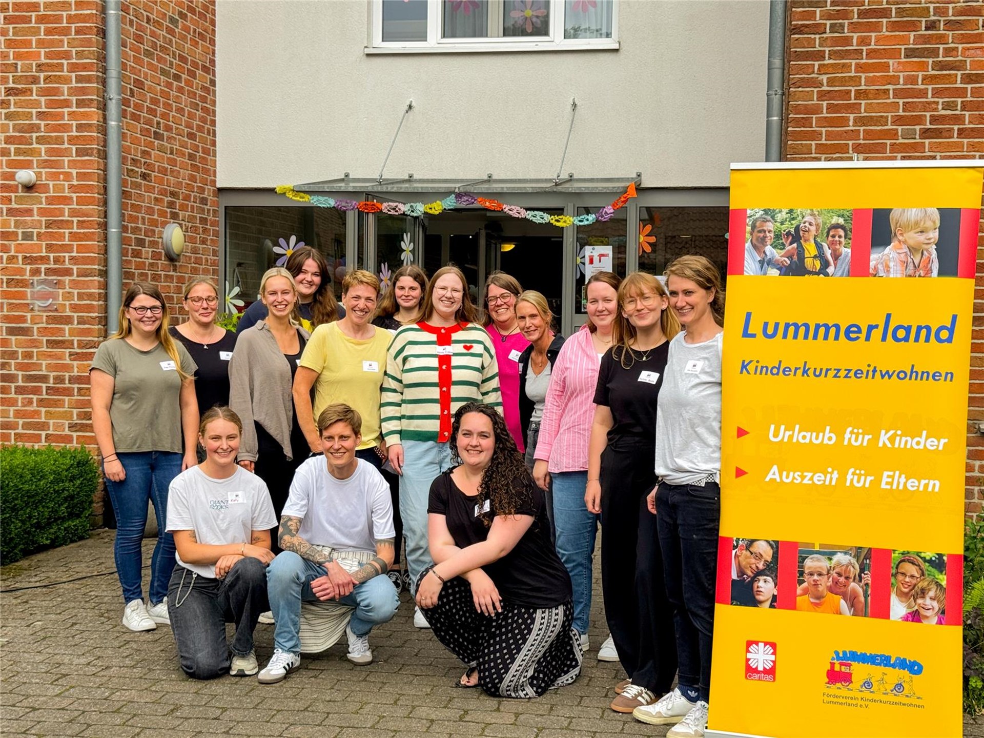 Die Mitarbeitenden des Lummerlands stehen vor dem Eingang der Einrichtung. 