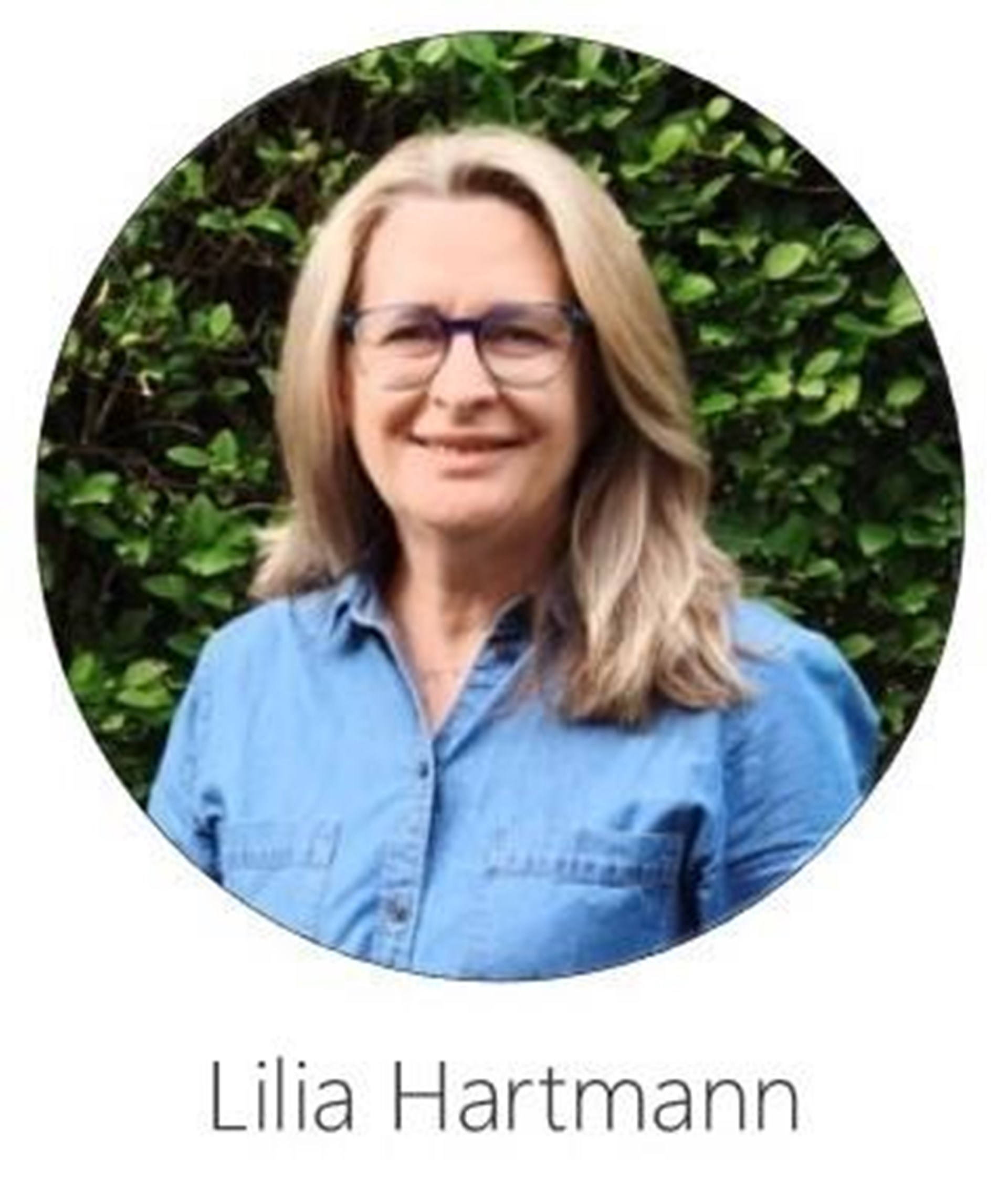 Das Portrait einer Frau mit blauer Jeansbluse und Brille