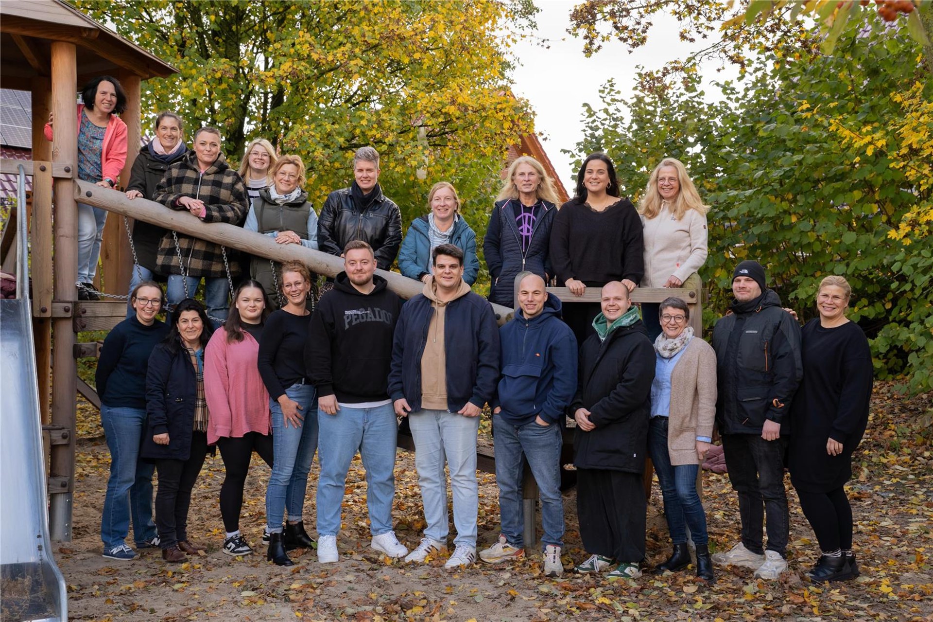 Die Mitarbeitenden des Familienzentrums Arche Noah stehen vor einem Klettergerüst. 